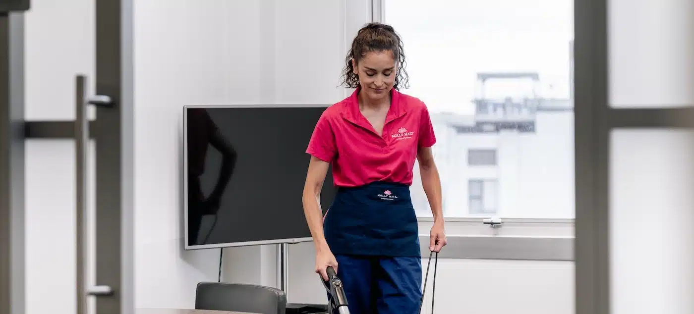 Molly Maid employee cleaning a small business office.
