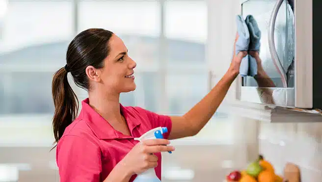 A Molly Maid Cleaning Team member cleaning a mirror